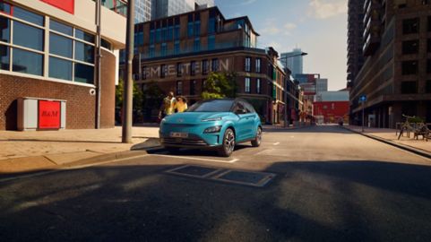 Kona Electric, jedoucí na silnici za ranního slunce.